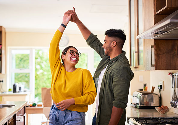 A young couple dancing in the kitchen