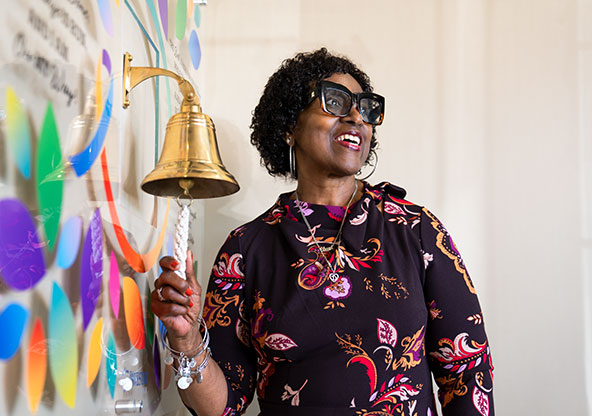 Debra rings a bell signifying that she is in full remission of breast cancer.