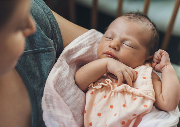 A mom holding her newborn baby girl