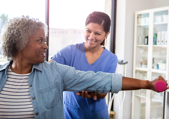 An elderly black woman doing cardiac rehabilitation with her therapist