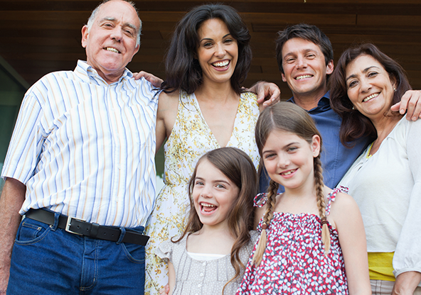 A multi-generational family standing together on the patio